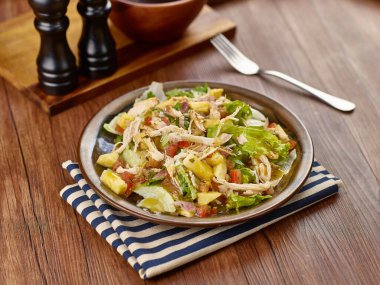 Sağlıklı Sezar Salata Kasesi peçeteye izole edilmiş, ahşap masa kenarı manzaralı tek kişilik yemek.