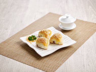 Fırınlanmış BBQ Bal Pork Pastası gri arkaplanda mat tarafında izole bir tabakta servis edilir.