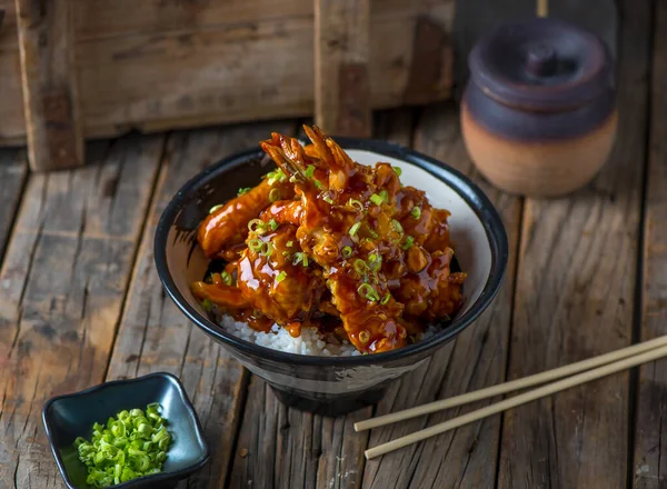 TENDON Donburi Japon yemeklerini ahşap arka planda yalıtılmış bir tabakta servis ediyordu.