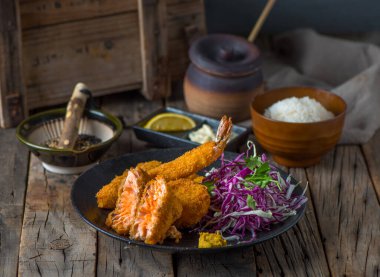 Beyaz pirinç ve salatayla servis edilen MIX SEAFODS katsudonu ahşap arka planda Japon yemeklerini gösteren bir tabakta servis ediliyor.