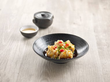 Pork Dumpling in Hot Chilli Vinaigrette ve sos gri mermer arka plan Japon yemeklerinde servis edilir.