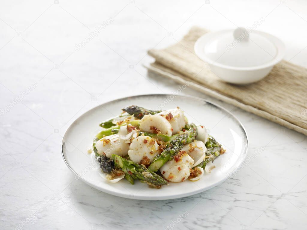 Sauteed Scallops with Lily Bulbs and Asparagus in XO Sauce served in a dish side view on grey background