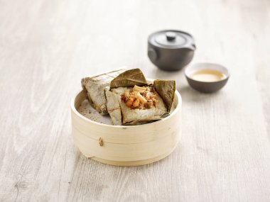 Buharda pişirilmiş Glutinous Rice ve Lotus Yaprağı ahşap bir kasede servis edilir yemek çubukları da gri mermer arka planda mat tarafında izole edilir.