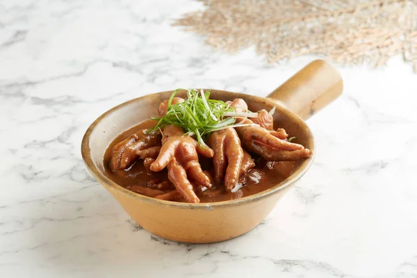 Stewed Chicken Claw in Abalone Sauce with chopsticks served in a dish isolated on grey background side view