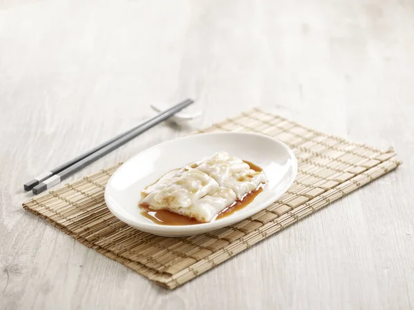 Steamed Rice Roll with Preserved Turnip Filling served in a tray with chopsticks isolated on mat side view on grey marble background