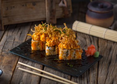 Osaka maki, ahşap arka planda izole edilmiş bir tabakta servis edilir.