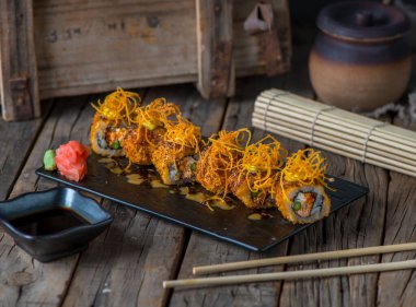 KAZUKI maki, ahşap arka plan görünümünde izole edilmiş bir tabakta hizmet verdi