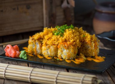 Fuji maki ahşap arka planda izole edilmiş bir tabakta servis edilir.