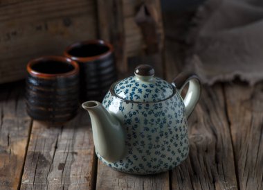 Çay fincanları ve çaydanlığı olan ev içi kahve masası ya da ahşap masa manzarası olan çaydanlık.