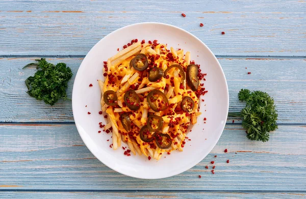 Tabakta servis edilen peynirli patatesler ahşap masa üstü fast food manzarasında izole edilmiş.