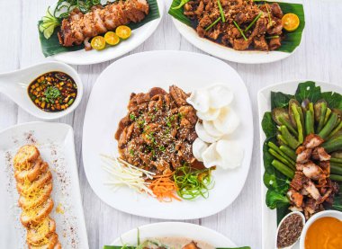 Assorted Philippines food Beef Bulgogi, Chicken Cordon bleu, Crispy Bagnet, Bagnet Kare-kare, lime and sauce served in dish isolated on grey wooden background side view of fastfood