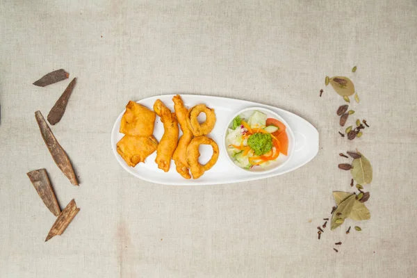 crunchy pakora with onion, murgh, chicken, baigan, salad and chutney served in a dish isolated on table top view of indian spices food