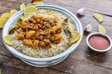 Arabian shrimp mandi with lime slice and sauce served in dish top view of middle east food