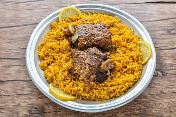 Arabian Kabsa meat rice with lemon slice served in dish top view of middle east food