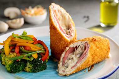 Chicken corden blu with salad vegetables isolated on cutting board side view of fastfood