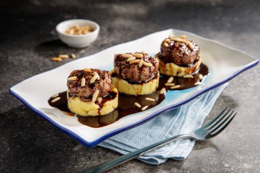 Püre püre ile servis edilen kofta peçete tarafında hazır yiyecek manzarası olan bir tabakta servis ediliyor.