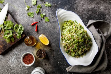 Limon dilimli kinoa salatası ve ahşap masaya konmuş bir tabakta servis edilen karabiber.