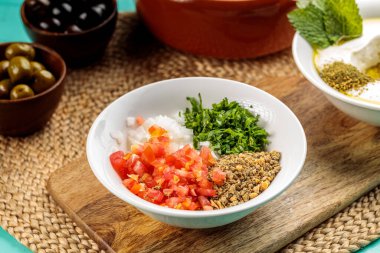 Taze Chanklish, sağIıklı yemek kasesinin tahta tarafında izole edilmiş bir tabakta servis edilir.