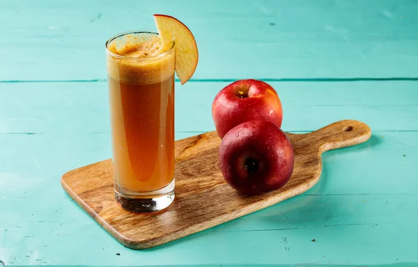 Fresh Apple Juice with raw apples served in a glass isolated on cutting board side view healthy fruit juice