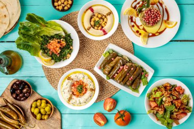Türlü Arap yemekleri Hommus Beyruti Etleri, Baba Ghanouj, zeytin, civciv bezelye, Pita Ekmeği Yaprakları, Tabbouleh, Fattoush, ahşap masa başı yemeklerde servis ediliyor.