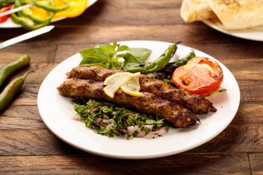 Salatalı tavuk kebabı, ahşap masa arkaplanındaki fast food manzaralı bir tabakta servis edilir.