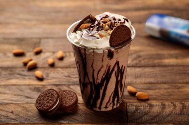 Oreo bisküvili Oreo milkshake, ahşap masa yemeğinin cam kenarında servis edilen badem.