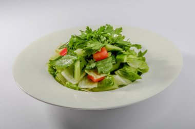 Taze yeşil salata, salatalık, domates ve yapraklarla servis edilen Arap yemeği.