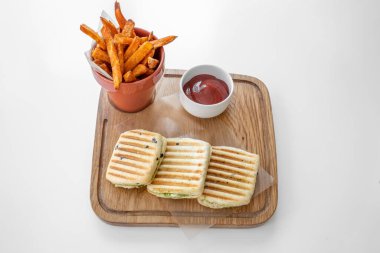 Kızarmış patates ve domates soslu tavuk pesto gri arka planda izole edilmiş bir tabakta servis edilir.