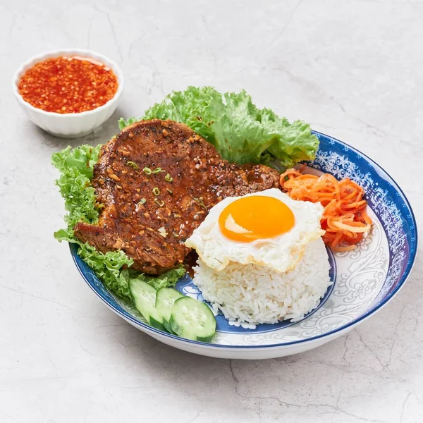 Vinaigrette Pork Chop with Rice, egg, noodle, chili sauce and salad served in a dish isolated on grey background side view of vietnam food