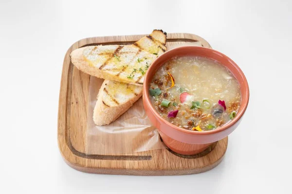 Chicken Corn Soup with garlic bread served in a bowl isolated on grey background top view