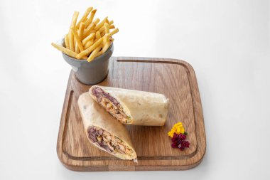 Shawarma Burrito ve patates kızartması gri arka planda izole edilmiş bir tabakta servis edilir.
