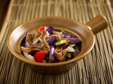 Tuzlu balık ve domuz dilimli patlıcan. Masa kenarında yalıtılmış bir çömlekte servis ediliyor.