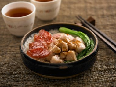 Tavuklu ya da Çin sosisli pilav. Masa manzarasında izole edilmiş bir tencerede servis ediliyor.