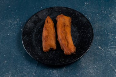 Kızarmış brinjal pakora ya da beguni arka planda izole edilmiş Hint ve Bengali yemeklerinin üst görüntüsünde servis edilir.