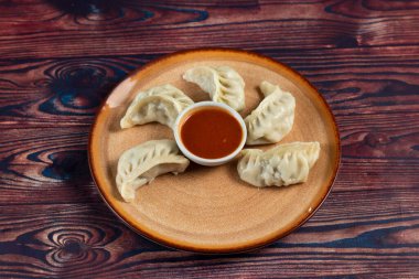 Arka planda izole edilmiş bir tabakta servis edilen ketçaplı buğulanmış tavuk ana dürümü.