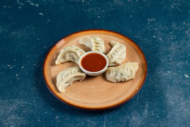 Arka planda izole edilmiş bir tabakta servis edilen ketçaplı buğulanmış tavuk ana dürümü.