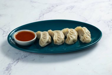 Arka planda izole edilmiş bir tabakta servis edilen ketçaplı buğulanmış tavuk ana dürümü.