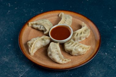 Arka planda izole edilmiş bir tabakta servis edilen ketçaplı buğulanmış tavuk ana dürümü.