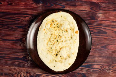 Roghni naan, khamiri roti, kulcha, ekmek veya chappati arka planda izole edilmiş bir tabakta servis edilir.