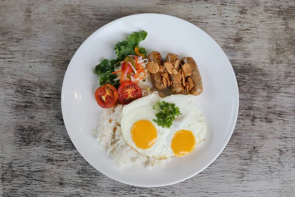 配上阳光明媚的鸡蛋的大蒜胡椒龙舌兰 配上西红柿和沙拉的米饭 放在木制背景的早餐视图中隔离的盘子里 — 图库照片