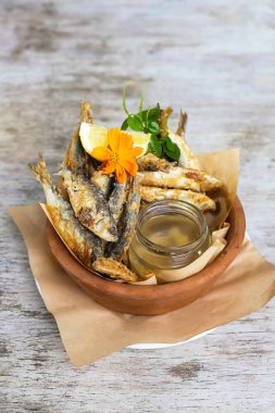 Cripy Fried Tawilis, Gri arka plan görünümlü abur cuburların olduğu bir tabakta servis edilir.