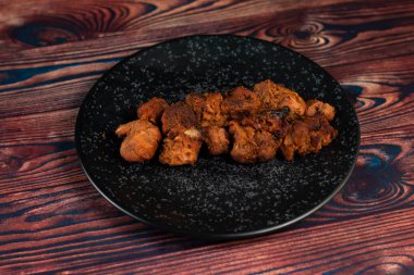 Baharatlı bbq tavuklu tikka boti kebap arka planda izole edilmiş bir tabakta servis edilir.