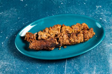 Baharatlı bbq tavuklu sebzeli kebap arka planda izole edilmiş bir tabakta servis edilir.