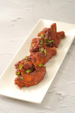 Tavuk kanadı barbeküsü fast food arka planında izole edilmiş bir yemekle servis edilir.