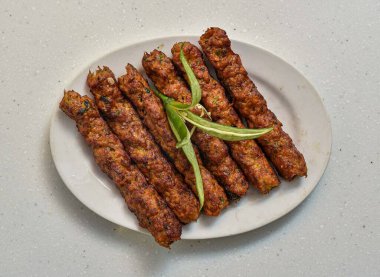 Baharatlı bbq Chicken seekh kebap Gri arka planda izole edilmiş bir tabakta servis edilir Hint ve Pakistan yemekleri üst görünümü