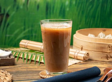 Tayvan yemeğinin ahşap bir tabağında servis edilen peçeteli sıcak süt çayı.