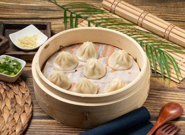 Xiao Long Tang Bao ahşap kaşık ve peçeteyle Tayvan yemeğinin ahşap bir tabağında servis edilir.