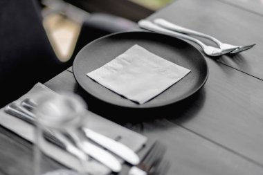 Lokantada siyah tabak, çatal bıçak ve peçete..