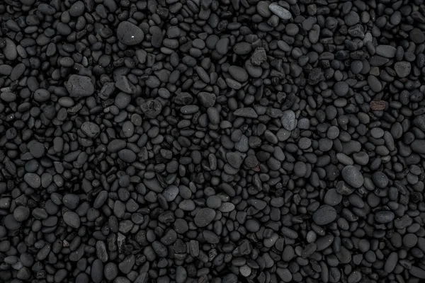 Beautiful black lava stone background texture, full frame shot of the black pebbles at Djupalonssandur beach, Iceland