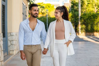 Şık, sevgi dolu, etnik bir çift şehirde birlikte yürüyor.